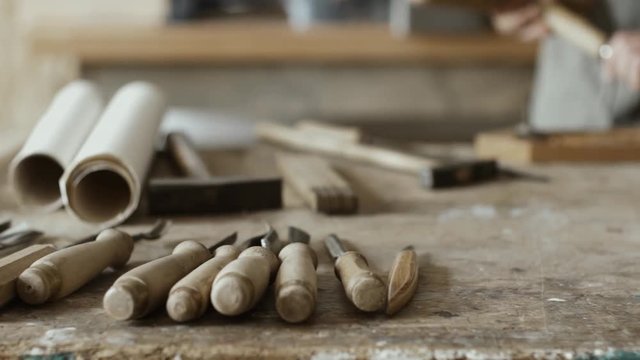 Skilled carpenter carving wood with mallet and chisel