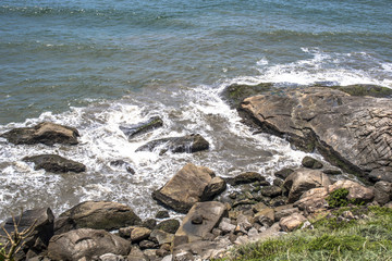 Waves hit the rocks on a beach in Itanhaem