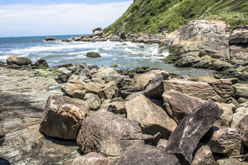 Fototapeta na wymiar Waves hit the rocks on a beach in Itanhaem