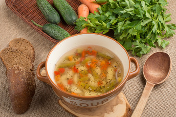 Vegetable soup surrounded by fresh vegetables.