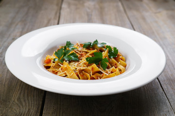 Pasta Fettuccine Bolognese in tomato sauce with chicken and parsley. Traditional Italian cuisine, delicious food, restaurant menu concept