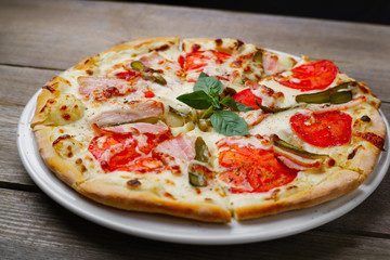 Pizza with bacon and gherkins, close up. Delicious italian cuisine, family restaurant, pizzeria, food recipe, pizza delivery concept