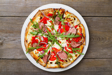 Pizza with veal and arugula, flat lay. Delicious italian cuisine, deluxe restaurant, pizzeria, chef's recipe concept