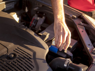 close up hand adjusting car mechanic opening hood during sunset