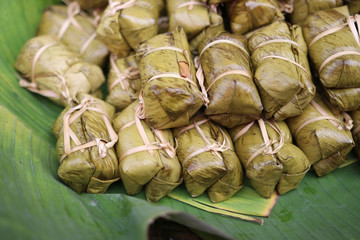 Fototapeta na wymiar Bananas with Sticky Rice for traditional on banana leaves in the basket Asian snack