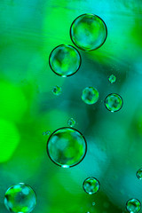 Green drops of oil in water