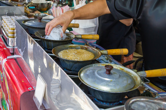 A man is cooking Thai food with boiled pot