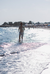 Boy running in water on the beach