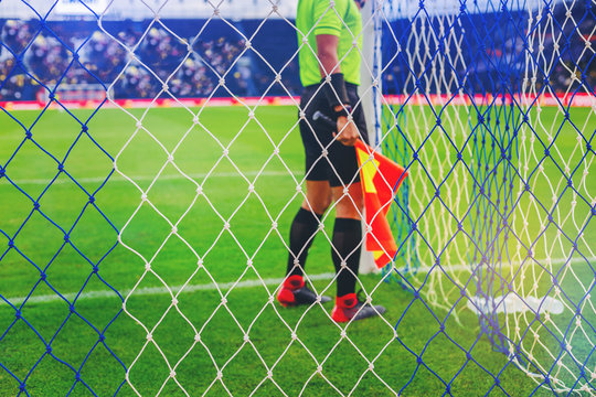 Lineman assistant referee checking a net of goal in soccer field before game start.