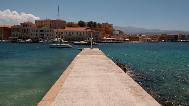 POV along a jetty in the promenade of Chania Old Town, Crete, Greece on a sunny day