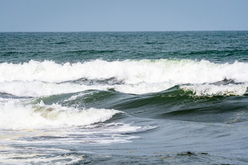 Waves breaking on the Caribbean Sea with blue sky in the background, as a nature background
