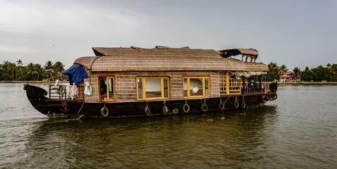 Fototapeta na wymiar Bamboo thatched houseboat floats down the backwaters of Kerala
