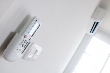 Remote control close up with air conditioner hang on white wall. Air conditioner inside the room remote controller.