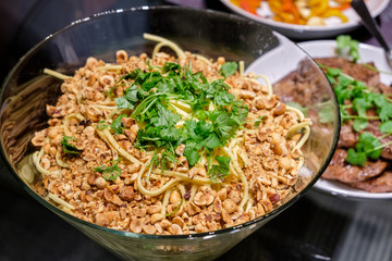 Dry spaghetti noodles with ground nuts and parsley in bowl