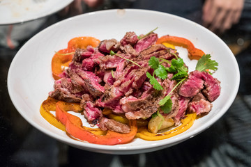 Beef steak sliced with tomato and potato on white plate