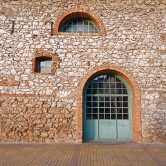 Fototapeta na wymiar vintage industrial building entrance with light green arched door