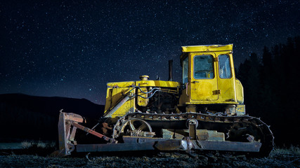 Yellow bulldozer under the starry sky blue