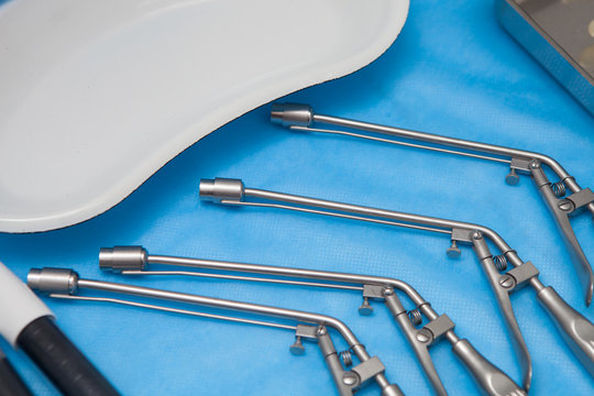 Ligators for the treatment of hemorrhoids made of stainless steel on blue medical tablecloths