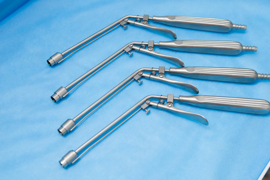Ligators for the treatment of hemorrhoids made of stainless steel on blue medical tablecloths