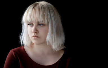 Naklejka premium Portrait of teenager with depression sitting alone in dark room. Sadness, nostlagic, depression. Problems of young people.