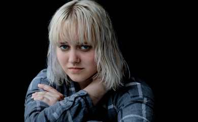 Close up of teenager with depression sitting alone in dark room. Sadness, nostlagic, depression. Problems of young people.