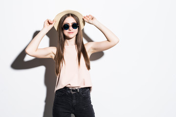 Beautiful young woman in fashion hat and sunglasses posing on white background