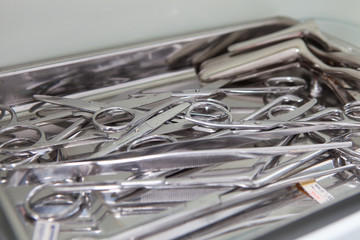 Medical scissors, tweezers and other tools in a stainless steel tray