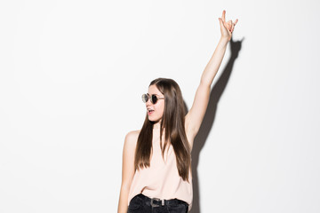 Pretty young fashion sensual woman posing on white wall background with rock gesture