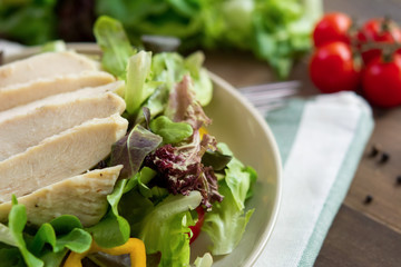 Salad toppped with skinless chicken breast