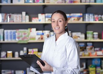 Beautiful pharmacist using notepad at the pharmacy