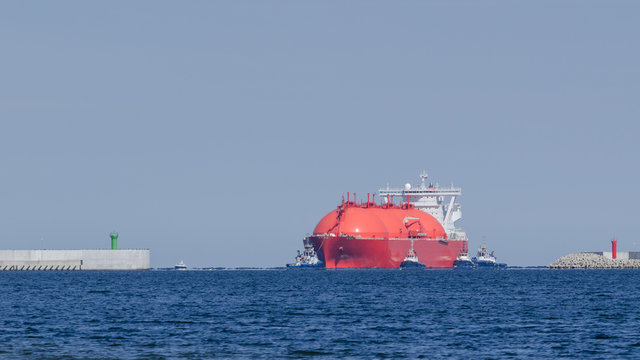 LNG TANKER - The red ship enters port with assurance of tugs