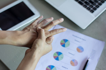Hand of young women there is pain in the hands caused by use computer . causes his fingers to lock and he is press point pain.