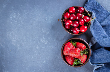 Food Background. Summer Berries Strawberry and Cherry in wooden plate on blue concrete table background. Healthy Concept. Top view, copy space