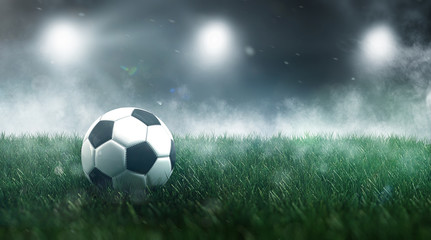 Fototapeta na wymiar Soccer ball or football in a misty sports stadium
