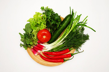 fresh vegetables and herbs laid out on a wooden Board 