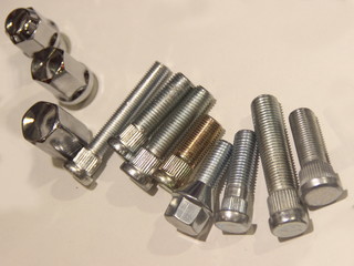 New car wheel studs on white table - auto parts