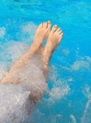legs of a lady who relaxes in the hot tub