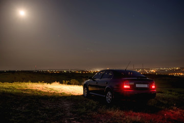 Fototapeta na wymiar Black car in the field at night