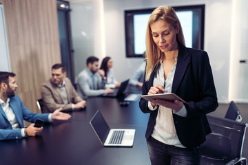 Attractive businesswoman using digital tablet in office