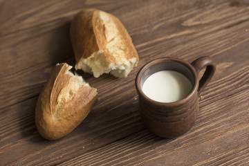 Obraz na płótnie Canvas ripped bread and cup of milk