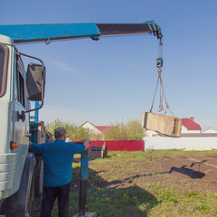 The crane loads old concrete blocks at the construction site