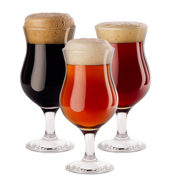 Decorative composition of different beer in wineglasses with foam - lager, red ale, porter -  isolated on white background.