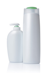 Blank white mockup dispenser and plastic bottles of cosmetic products with green lids