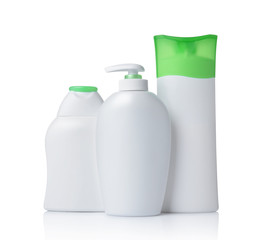 Blank white mockup dispenser and plastic bottles of cosmetic products with green lids