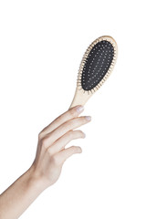 Female hand holding a hairbrush on isolated background