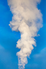 Obraz premium smoke from a pipe in the factory against a blue sky