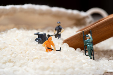 Miniature people: Men are working hard in raw rice mountain in a bamboo basket, the concept of labor. No pain, no gain. 