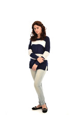 full length portrait of girl wearing striped blue and white jumper and jeans. standing pose on white studio background