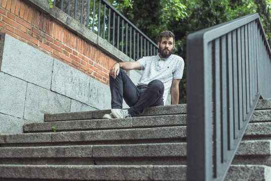 joven sentado en escaleras con ropa casual