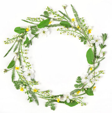 Round frame wreath made of spring flowers and leaves isolated on white background. Flat lay. Top view.